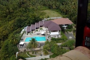 A resort with multiple buildings, a swimming pool, and a surrounding tropical landscape. - Panorama de Argao Boutique Resort (Argao)