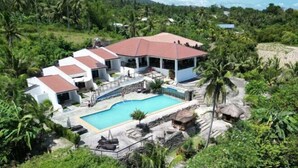 A resort with multiple buildings, a swimming pool, and lush tropical surroundings. - Panorama de Argao Boutique Resort (Argao)