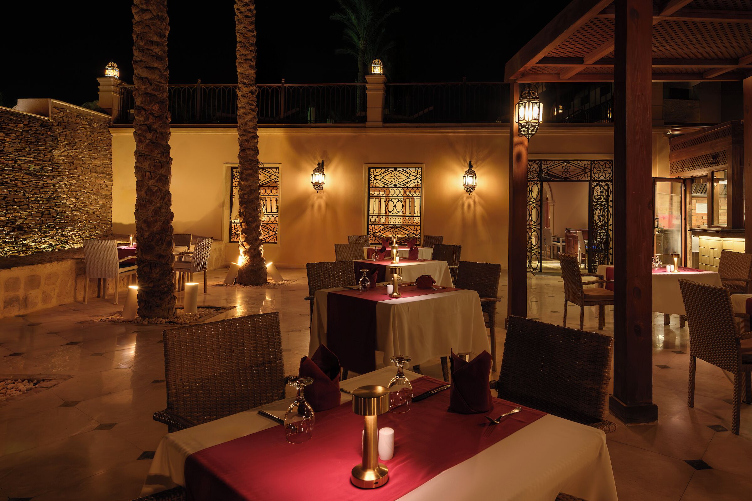 An outdoor dining area with tables, chairs, and decorative lighting.