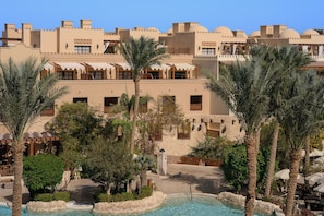 Un resort con piscina, palmeras y arquitectura tradicional.