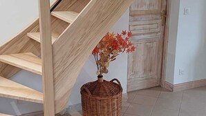 A wooden staircase with a woven basket containing dried flowers at the base. - Group Gîte: Domaine de la Vacquerie (Alette)