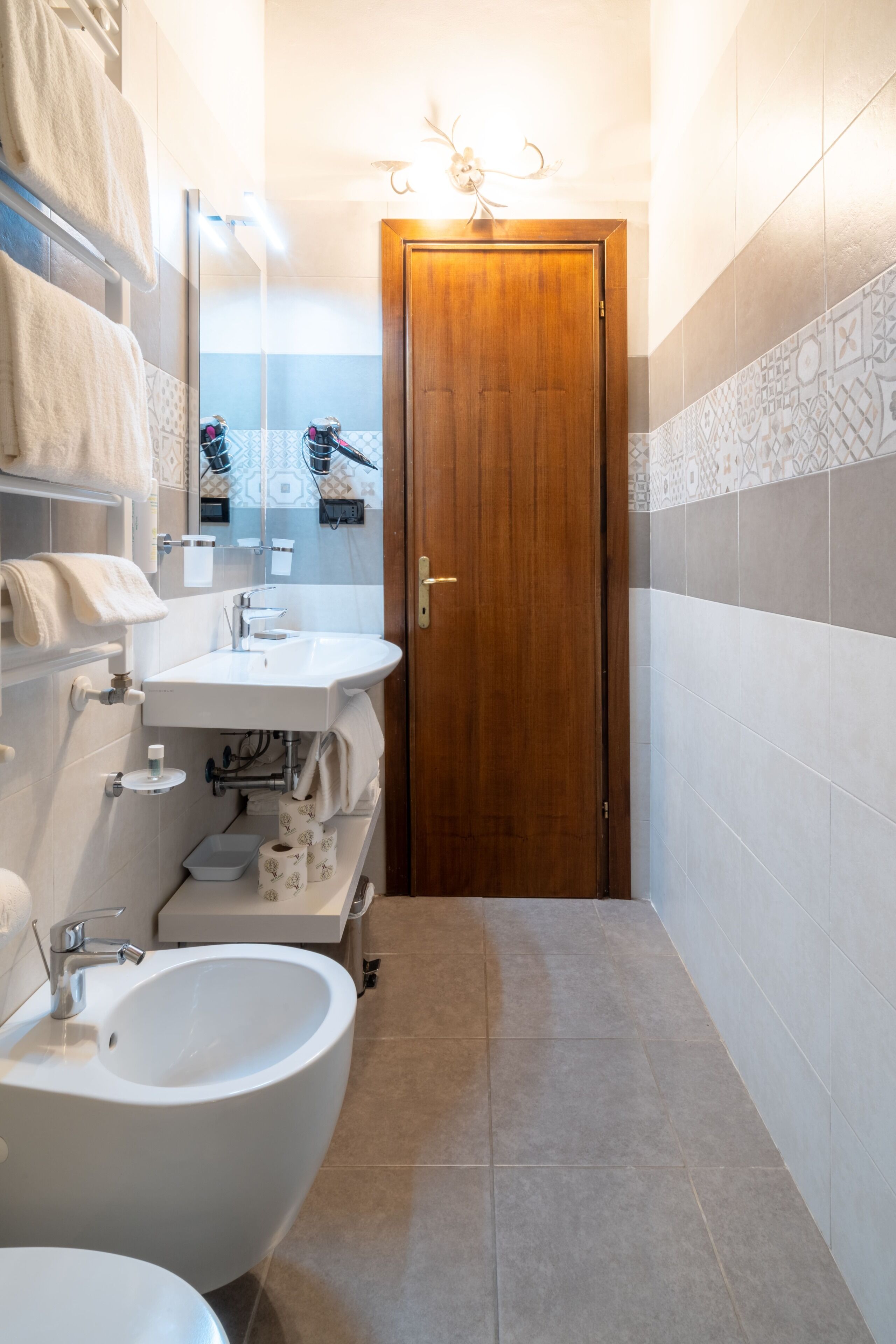 A bathroom with a sink, bidet, and toilet.