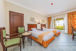 Deluxe Room Garden/Sea View | Tabla de planchar con plancha y ropa de cama