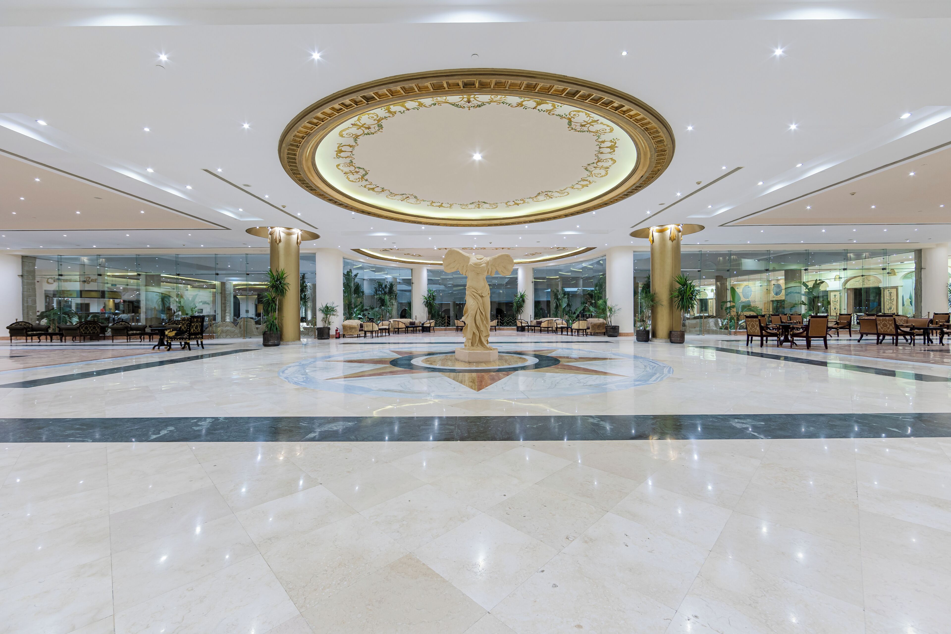 A spacious lobby with a central statue, large columns, and a star-patterned floor.