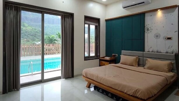 Une chambre spacieuse avec un grand lit, un ventilateur de plafond et un appareil de climatisation.