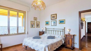 Ein Schlafzimmer mit Bett, Nachttischen, einer Hängelampe und gerahmten Bildern an der Wand.