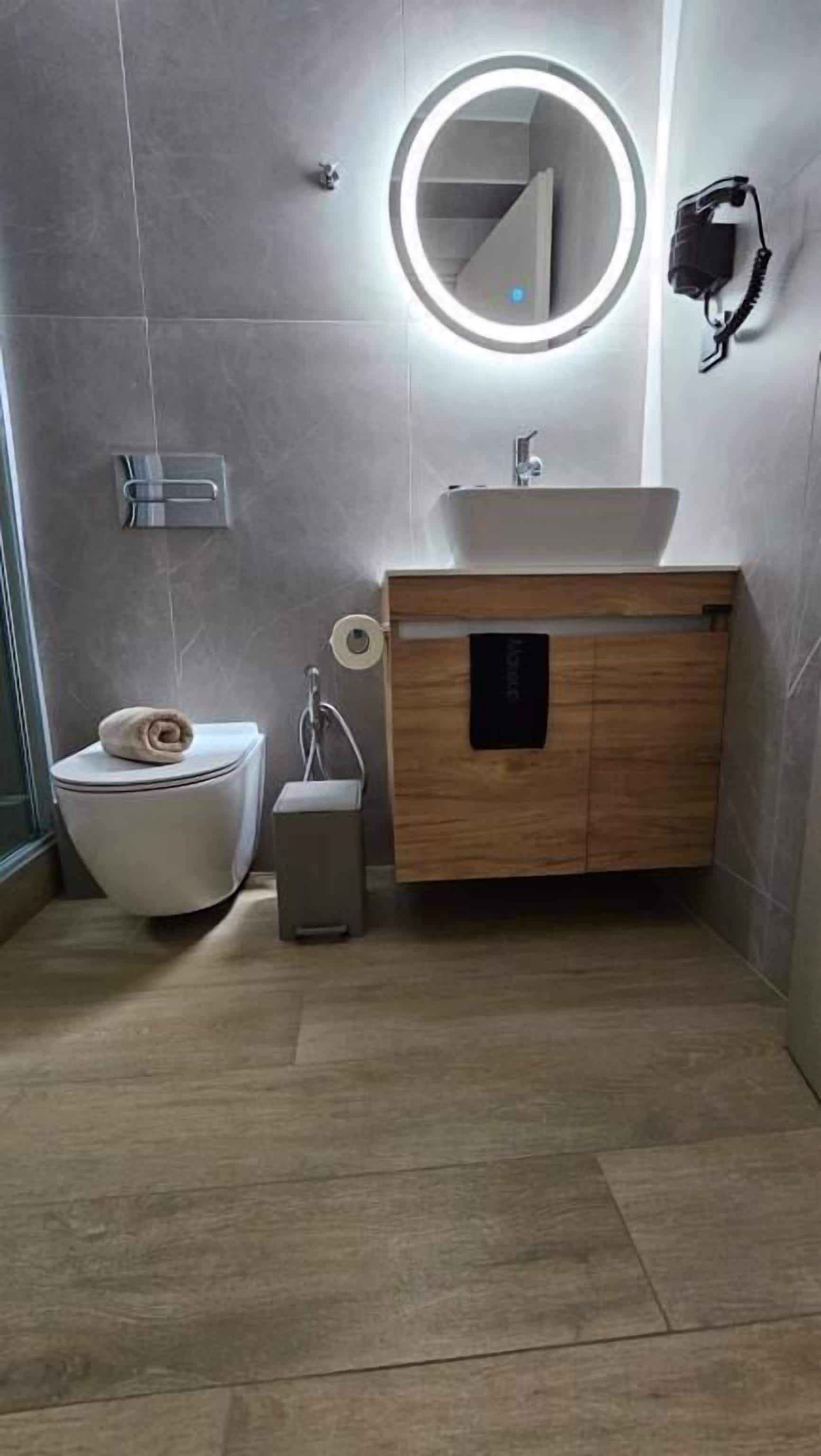 A modern bathroom with a toilet, sink, and mirror.