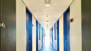 A long, narrow hotel corridor with doors on both sides, leading to individual rooms. - Horison Kuta Bali (Kuta)