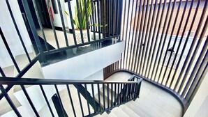 A modern staircase with black railings and a white wall. - Horison Kuta Bali (Kuta)