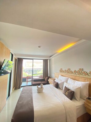A hotel room with a bed, a flat-screen TV, a balcony, and a view of the outside. - Horison Kuta Bali (Kuta)