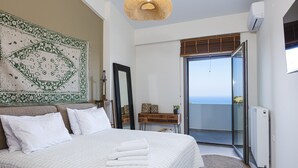 A bedroom with a large bed, a mirror, a dresser, and a view of the balcony. - Luxurious Villa Rizes - with Private Pool (Maroulas)