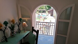 Une pièce comprenant une table, une chaise, une lampe et des plantes décoratives.