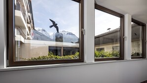 A window with a view of a mountain and a bird in flight. - Vacation apartment Bergkristall with Watzmann view (Berchtesgaden)