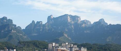 Paisagem urbana com edifícios modernos e uma cordilheira ao fundo.