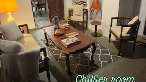 Una sala de estar acogedora con chimenea, asientos cómodos y obras de arte en las paredes.