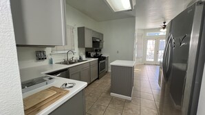 A modern kitchen with grey cabinets, a stainless steel refrigerator, and a dishwasher. - 3-bedroom house in fabulous Helotes with AC (Helotes)