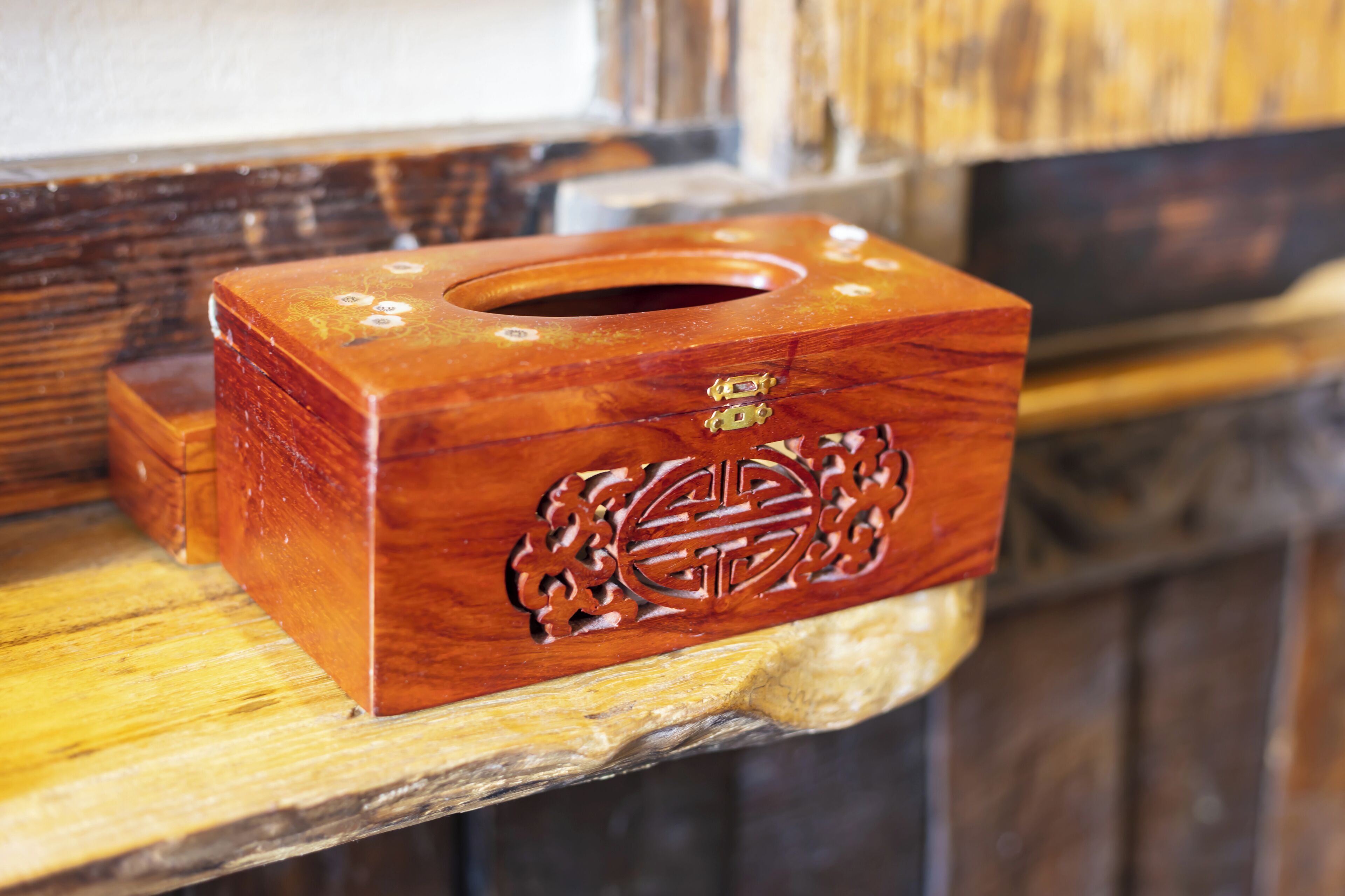 Un expositor de pañuelos de madera con tallas elaboradas sobre una superficie de madera.
