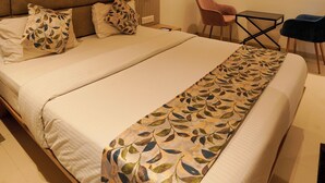 A modern hotel room with a large bed, a desk, and a chair. - The Food Villa (Mumbai)