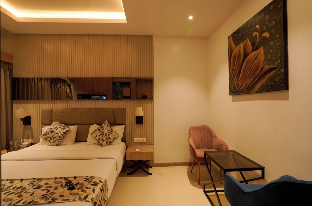 A modern hotel room with a large bed, bedside tables, a desk, and a chair.