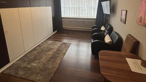 Ein modernes Wohnzimmer mit einer Couch, einem Holztisch und einem großen Kleiderschrank.