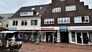 Straßenansicht mit Geschäften, darunter eine Rossmann Apotheke und ein Geschäft von Naturschuh-Kontor.