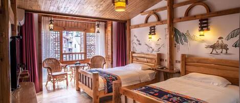 Una habitación de madera con dos camas, una mesa de comedor, sillas y un ventanal con cortinas.