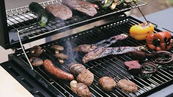 A grill with various meats and vegetables being cooked.