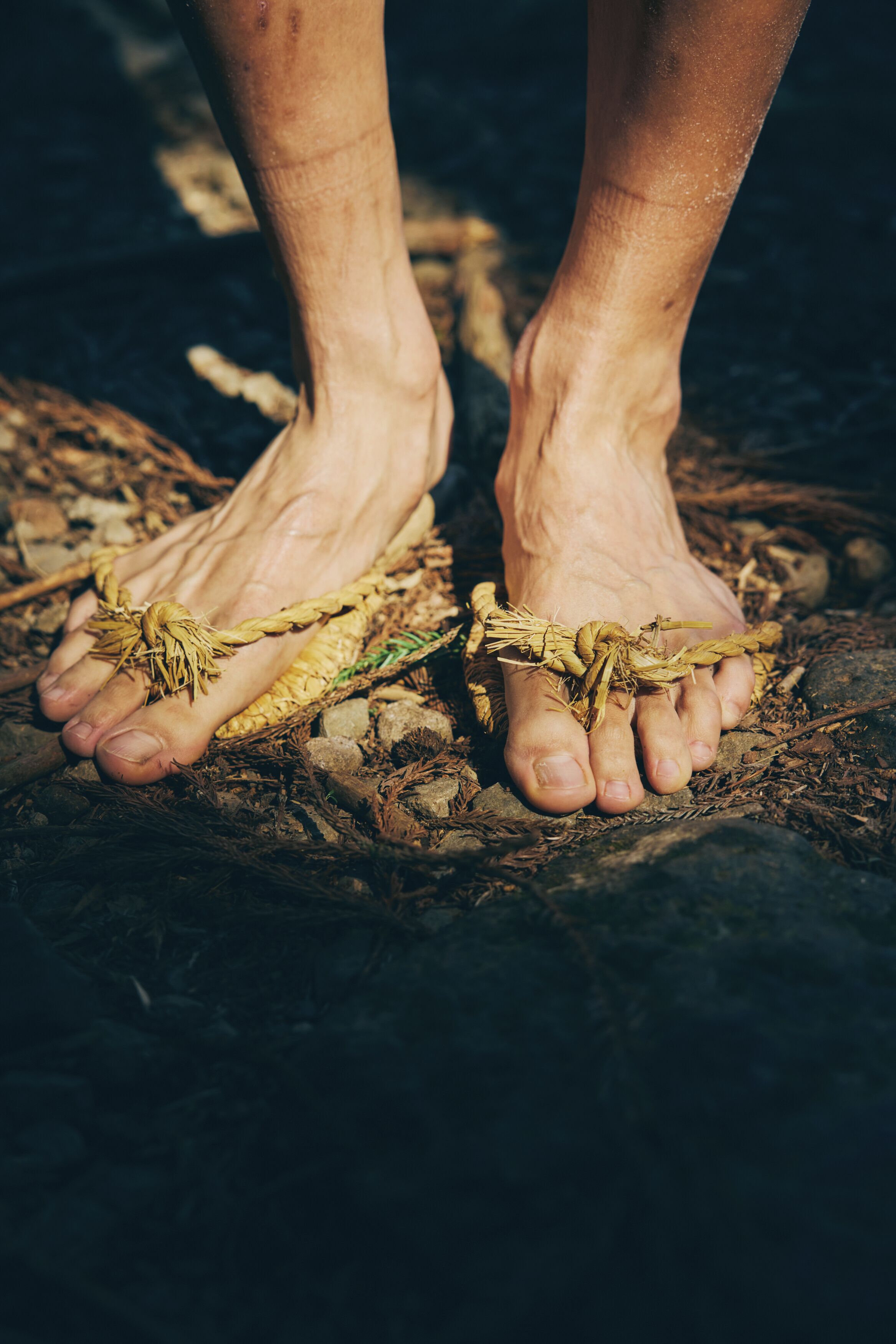 Un paio di piedi scalzi legati con una corda.