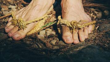 Un paio di piedi scalzi legati con una corda.