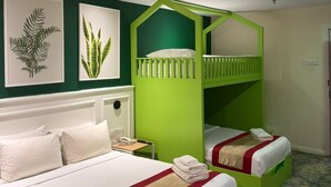 A room with a bunk bed, a single bed, and two framed plant artworks on the wall. - asto hotel (Kuala Lumpur)