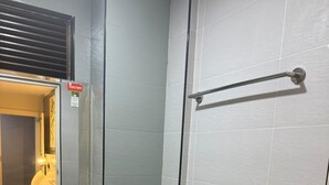 A small bathroom with a toilet, sink, and mirror. - asto hotel (Kuala Lumpur)