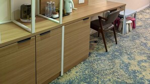 A compact room with a wooden desk, a chair, and a TV mounted on the wall. - asto hotel (Kuala Lumpur)
