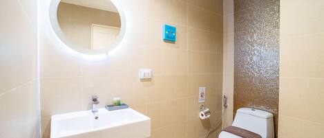 Ein Badezimmer mit Waschbecken, Spiegel, Toilette und Dusche.