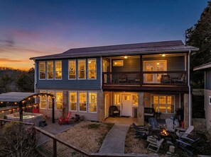 A two-story house with a covered patio, outdoor seating, and a hot tub. - Serene Smokies Retreat | Hot Tub | Fire Pit | BBQ (Sevierville)