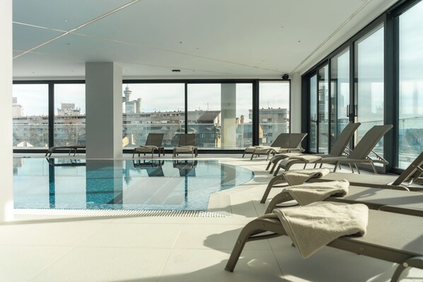 A rooftop infinity pool with lounge chairs and a city view. - New Belgrade Premium Hotel (Belgrade)