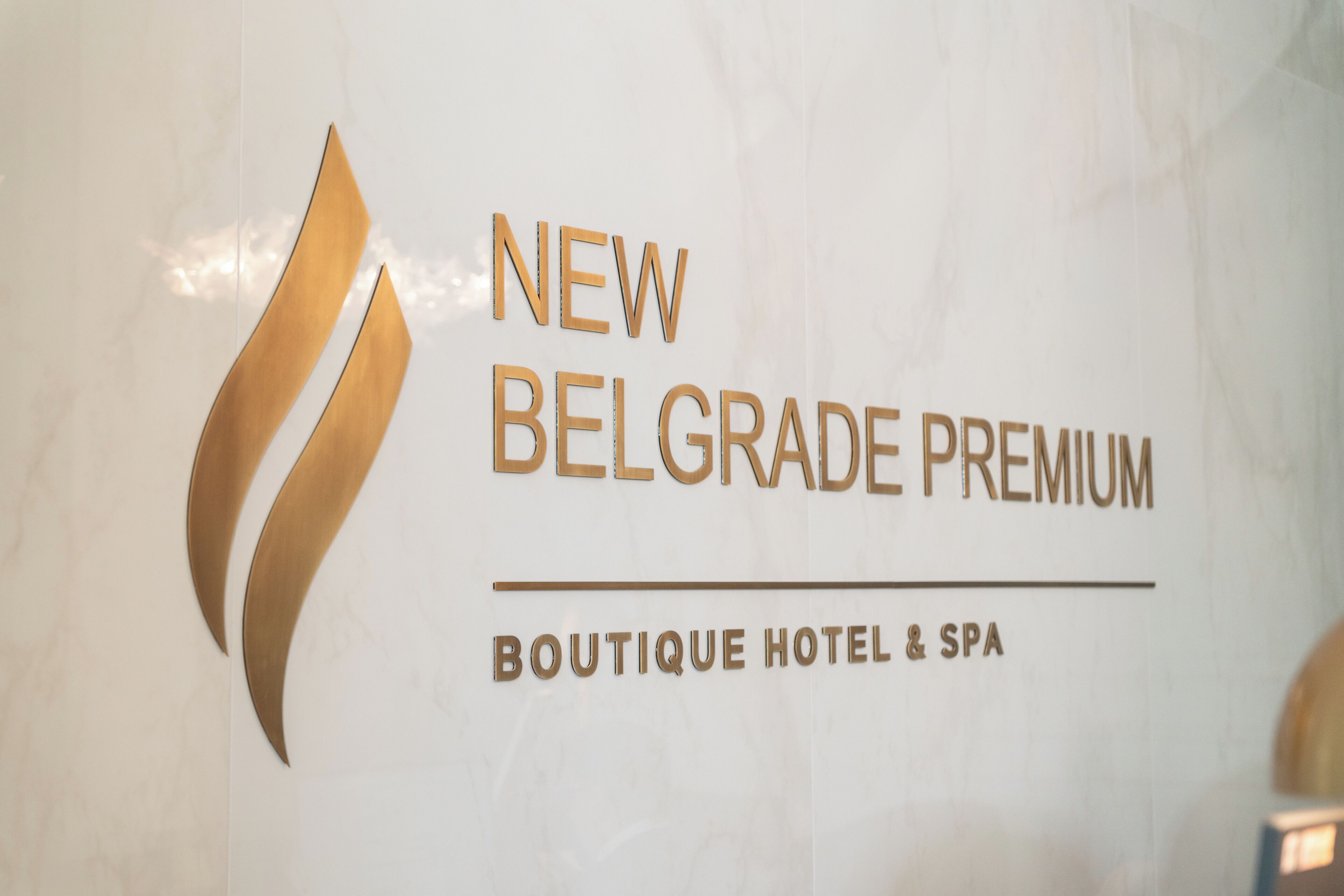 A sign for 'NEW BELGRADE PREMIUM BOUTIQUE HOTEL & SPA' with a stylized logo.