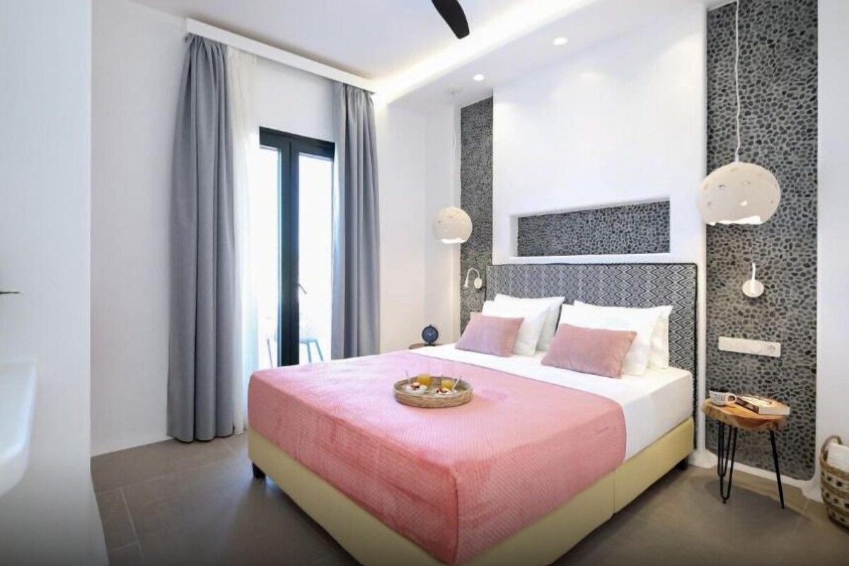 A modern bedroom with a bed, curtains, a ceiling fan, and a wall with a textured pattern.