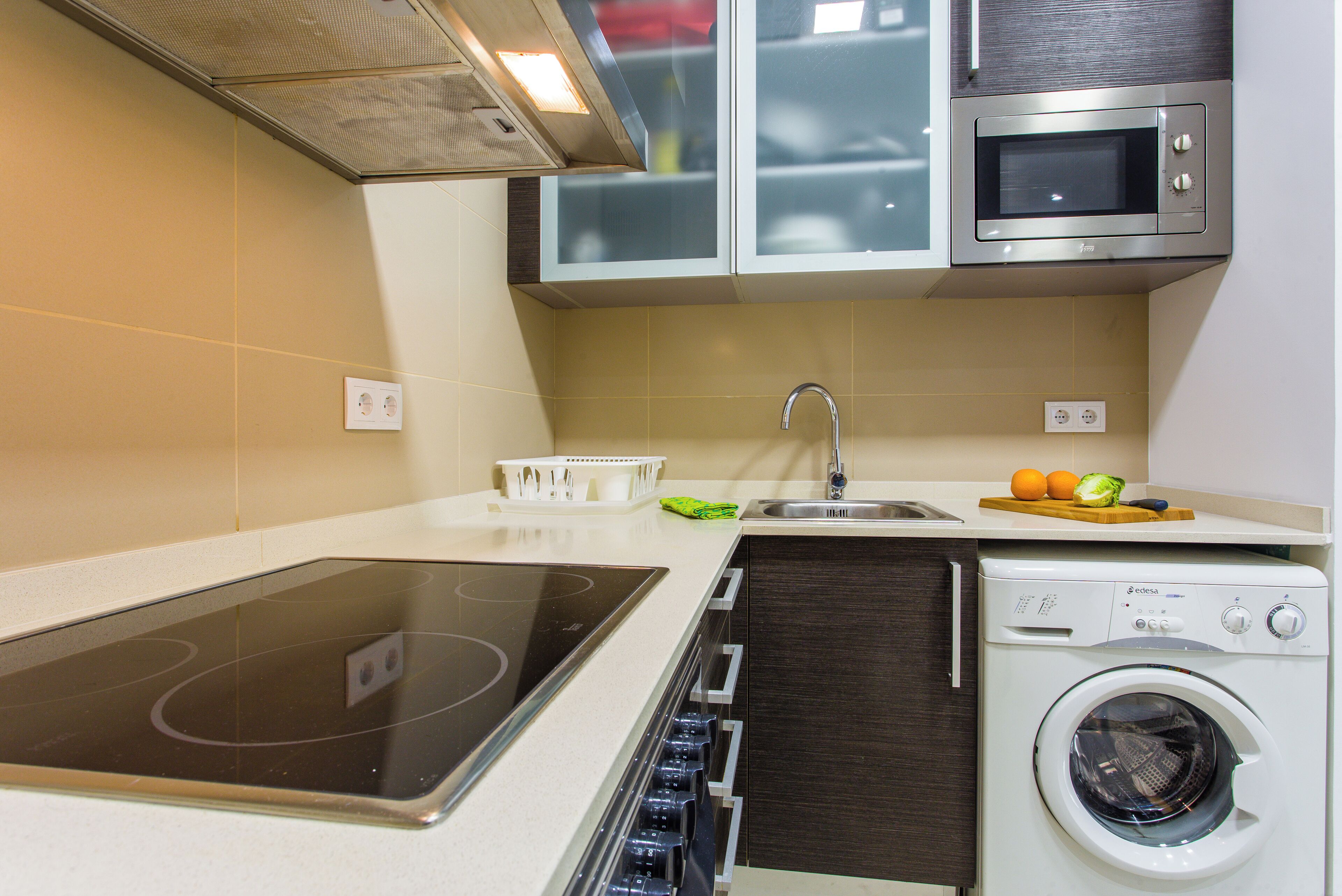 A compact kitchen with a built-in microwave, oven, and dishwasher.