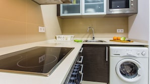 A compact kitchen with a built-in microwave, oven, and dishwasher. - Feriapiso Apartments Palmer (L'Hospitalet de Llobregat)