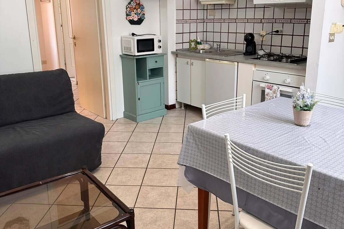 A compact kitchen with white cabinets, a microwave, and a gas stove.