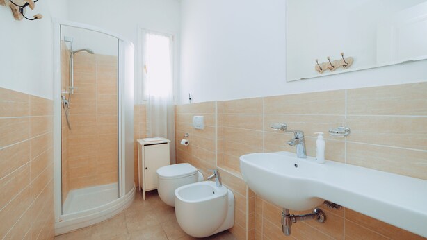 A modern bathroom with a shower, toilet, bidet, and sink. - Residence Porta Saragozza (Bologna)