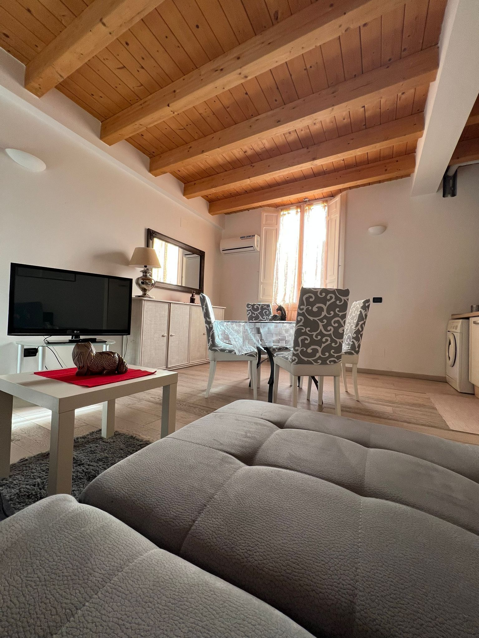 Un salon comprenant un téléviseur, un canapé, une table à manger et des chaises.