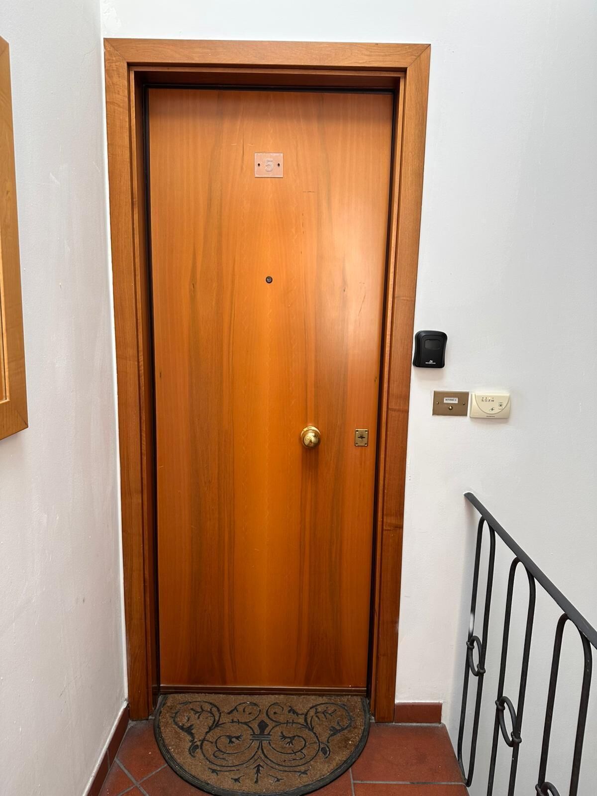 A wooden door with a doorknob and a small plate with a number.