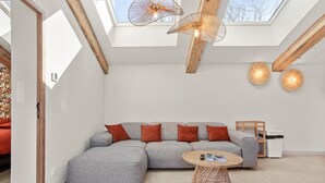 Ein modernes Wohnzimmer mit einer Eckcouch, einem runden Couchtisch und einem Oberlicht.