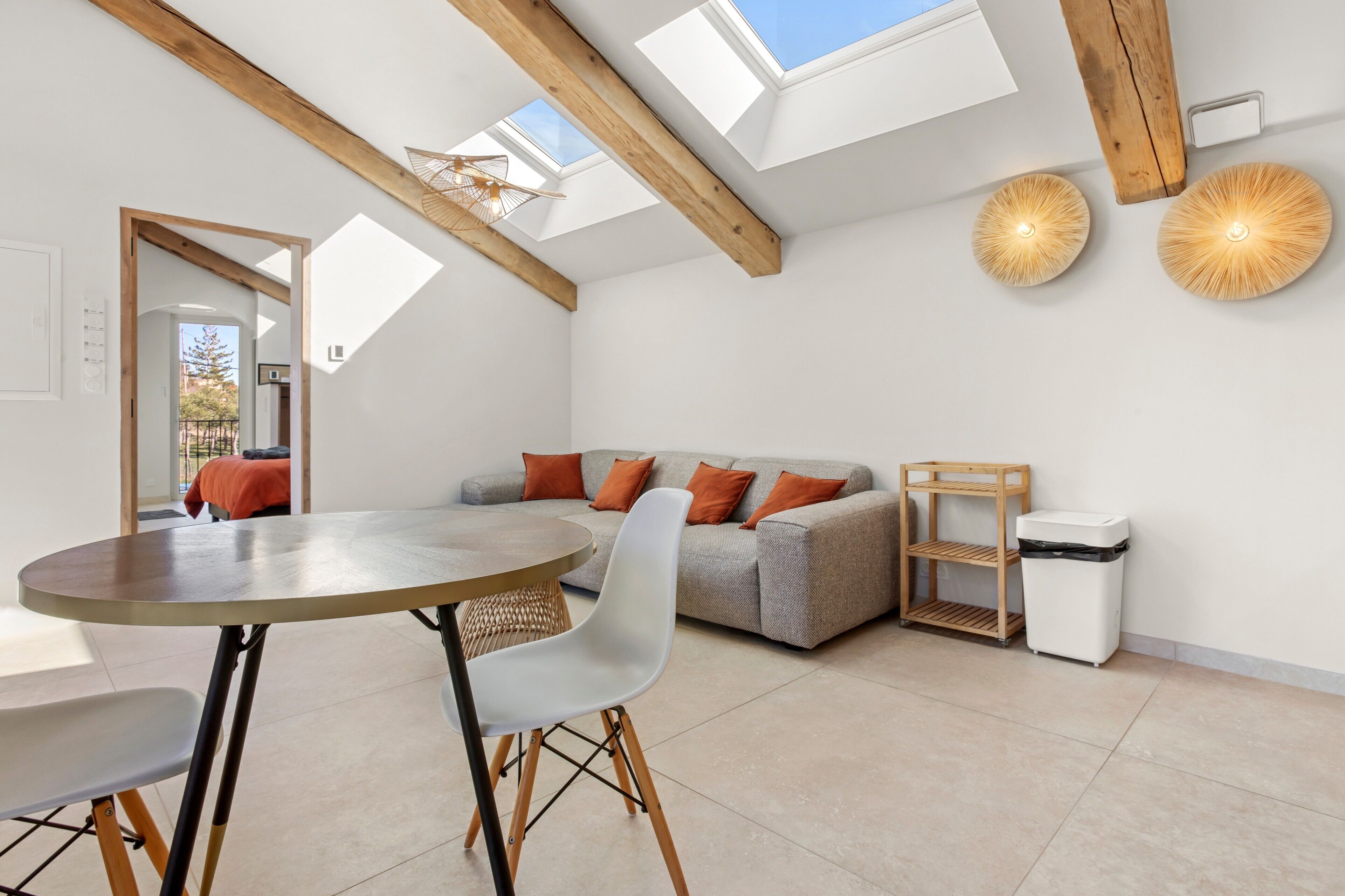 Een modern interieur met een eethoek, bank en dakraam.