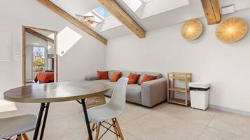 Een modern interieur met een eethoek, bank en dakraam.