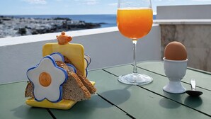 A table with breakfast items and a glass of orange juice, overlooking a beach. - Villa with sea views and private pool overlooking the harbour. (Tías)