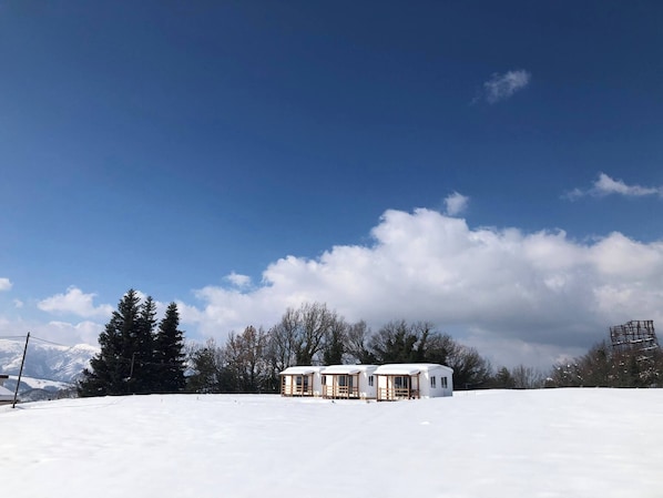 A snow-covered landscape with a small cabin structure.