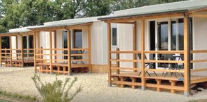 A row of single-story cabins with wooden railings and large windows.