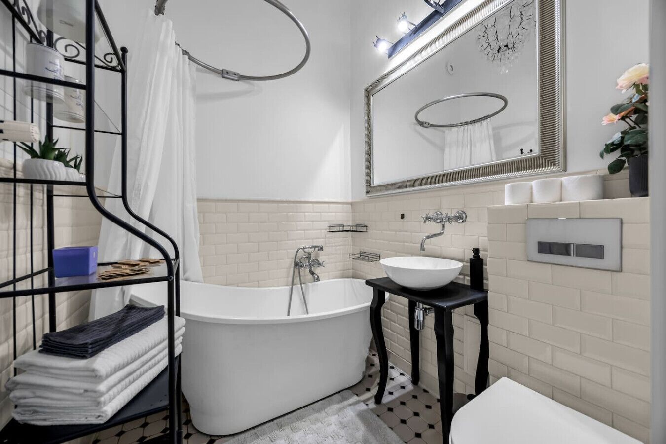 A modern bathroom with a freestanding bathtub, a white sink, and a large mirror.